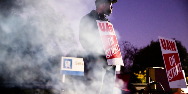 FILE- In this Sept. 27, 2019, file photo worker Omar Glover pickets outside a General Motors facility in Langhorne, Pa. A tentative four year contract with striking General Motors gives workers a mix of pay raises, lump sum payments and an $11,000 signing bonus. (AP Photo/Matt Rourke, File)