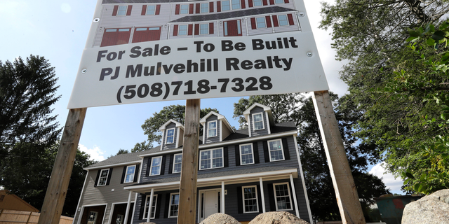 In this Sept. 3, 2019 photo a for sale sign, top, rests in front of a newly constructed home, in Norwood, Mass. On Thursday, Oct. 17, the Commerce Department reports on U.S. home construction in September. (AP Photo/Steven Senne)