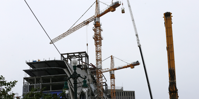 Workers in a bucket begin the process of planting explosive charges on two unstable cranes at the Hard Rock Hotel, which underwent a partial, major collapse Saturday, Oct. 12, in New Orleans, viewed Thursday, Oct. 17, 2019. Authorities say explosives will be strategically placed on the two unstable construction cranes in hopes of bringing them down with a series of small controlled blasts ahead of approaching tropical weather. Officials hope to bring the towers down Friday without damaging nearby businesses and historic buildings in and around the nearby French Quarter. (AP Photo/Gerald Herbert)