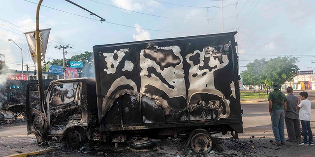 A burnt-out truck used by gunmen smolders on an intersection, a day after street battles between gunmen and security forces in Culiacan, Mexico, Friday Oct. 18, 2019.