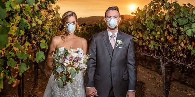 An Illinois couple got married in Northern California's famous Sonoma County on Saturday as a massive wildfire raged nearby, posing for a dramatic wedding photo as they wore masks, the photographer told Fox News.
