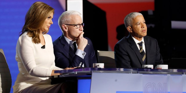 Erin Burnett, CNN anchor, from left, Anderson Cooper, CNN anchor, and Marc Lacey, New York Times national editor, listen during a Democratic presidential primary debate hosted by CNN/New York Times at Otterbein University, Tuesday, Oct. 15, 2019, in Westerville, Ohio. (AP Photo/John Minchillo)