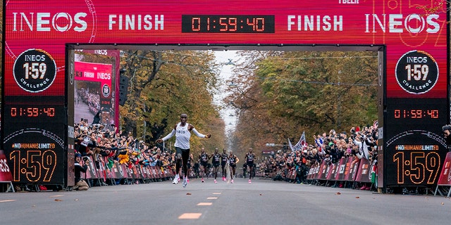 In this photo made available by The INEOS 1:59 Challenge on Saturday, Oct. 12, 2019, Eliud Kipchoge celebrates as he crosses finish line and makes history to become the first human being to run a marathon in under 2 hours. (Bob Martin/The INEOS 1:59 Challenge via AP)