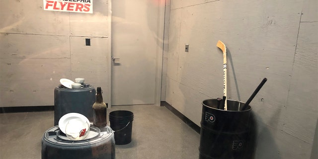 Hockey sticks sit in a barrel, right, in the