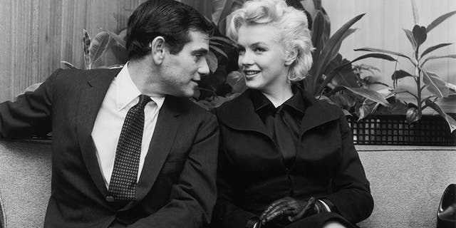 Marilyn Monroe (1926 - 1962) and photographer Milton Greene sitting and talking after their arrival from New York at LA Airport, Los Angeles, California.