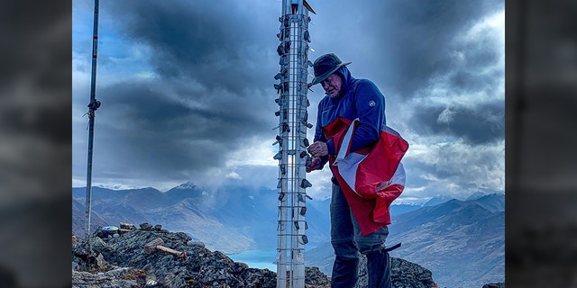 Gold Star Father Tom Wozencraft affixed the dog tags of his fallen heroes atop Gold Star Peak. (Keith Sherman)