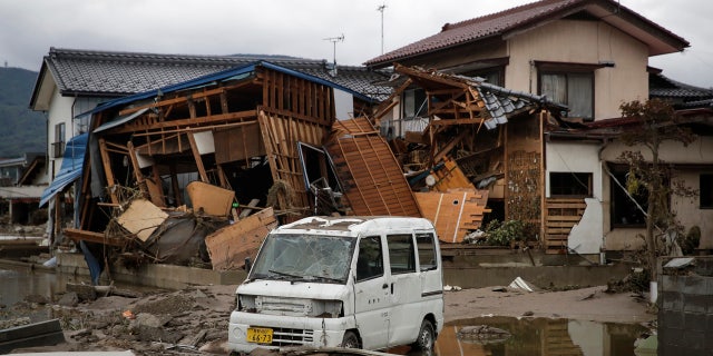 A vehicle sits in front of a home destroyed by Typhoon Hagibis Tuesday, Oct. 15, 2019, in Nagano, Japan.
