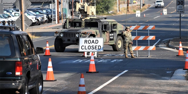 A member of Cal Guard blocks traffic from entering the town of Healdsburg on Monday following an evacuation order.
