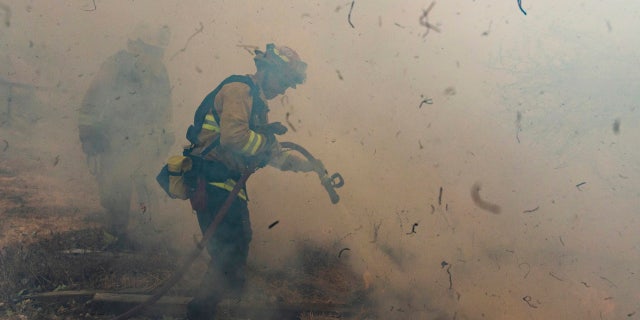 Firefighters from San Matteo work to extinguish flames from the Kincade Fire in Sonoma County, Calif., on Sunday, Oct. 27, 2019.