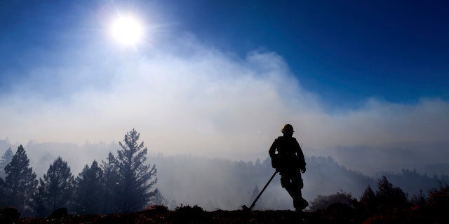 Firefighter Josh Petrell monitors the Kincade Fire burning near Healdsburg, Calif., on Tuesday, Oct. 29, 2019. AP Photo/Noah Berger