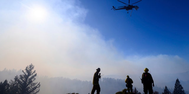 Firefighters monitor the Kincade Fire burning near Healdsburg, Calif., on Tuesday, Oct. 29, 2019.