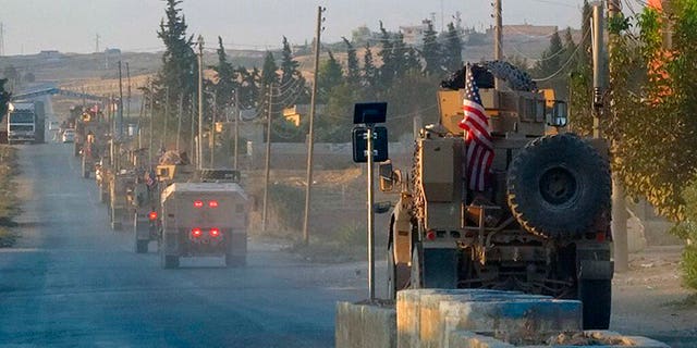 In this image provided by Hawar News Agency, ANHA, U.S. military vehicles travel down a main road in northeast Syria, Monday, Oct. 7, 2019. (ANHA via AP)