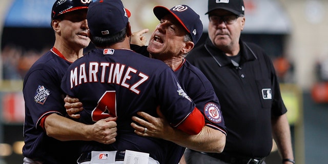 Washington Nationals manager Dave Martinez has to be restrained after being ejected for arguing an interference call during the seventh inning of Game 6 of the baseball World Series against the Houston Astros Tuesday, Oct. 29, 2019, in Houston. (Associated Press)