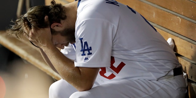 Los Angeles Dodgers pitcher Clayton Kershaw sits in the dugout after giving up back-to-back home runs to the Washington Nationals during the eighth inning in Game 5 of a baseball National League Division Series on Wednesday, Oct. 9, 2019, in Los Angeles. (AP Photo/Marcio Jose Sanchez)