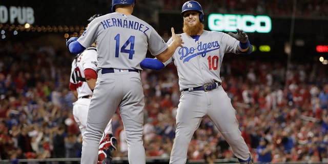 Los Angeles Dodgers third baseman Justin Turner (10) celebrates his three-run home run off Washington Nationals relief pitcher Wander Suero with Enrique Hernandez (14) during the sixth inning in Game 3 of a baseball National League Division Series on Sunday, Oct. 6, 2019, in Washington. (AP Photo/Julio Cortez)