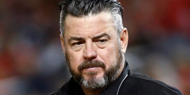 In this Sept. 13, 2019, file photo, umpire Rob Drake stands on the field during a baseball game between the Atlanta Braves and the Washington Nationals in Washington. Commissioner Rob Manfred says Major League Baseball will look into a politicized tweet by Drake that referenced a rifle and criticism of President Donald Trump. 