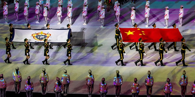 Soldiers from Chinese People's Liberation Army (PLA) parade with a Chinese national flag and a Military World Games flag during the opening ceremony of the 7th CISM Military World Games in China, this month. The Chinese military’s orienteering team was disqualified. (Reuters)