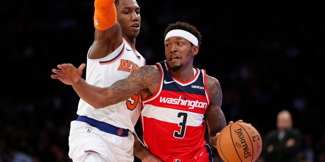 Washington Wizards guard Bradley Beal (3) drives around New York Knicks forward RJ Barrett during the first half of a preseason NBA basketball game in New York, Friday, Oct. 11, 2019. (AP Photo/Kathy Willens)
