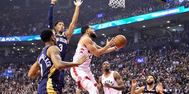 Toronto Raptors guard Fred VanVleet (23) goes to the basket as New Orleans Pelicans' Josh Hart (3) and Nickeil Alexander-Walker (0) defend during the first half of an NBA basketball game Tuesday, Oct. 22, 2019, in Toronto. (Frank Gunn/The Canadian Press via AP)