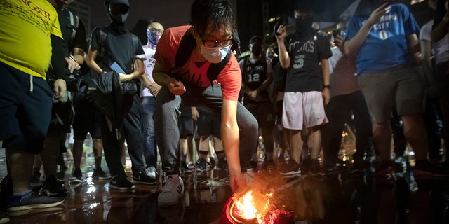 Demonstrators set a Lebron James jersey on glow during a convene during a Southorn Playground in Hong Kong, Tuesday, Oct. 15, 2019.  (AP Photo/Mark Schiefelbein)