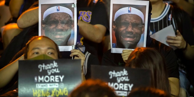 Demonstrators hold up photos of LeBron James grimacing during a rally at the Southorn Playground in Hong Kong, Tuesday, Oct. 15, 2019. (AP Photo/Mark Schiefelbein)