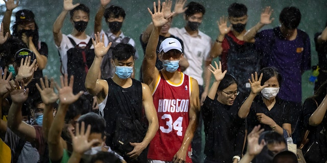 A malcontent wearing Houston Rockets jersey binds adult his palm with associate demonstrators during a convene during a Southorn Playground in Hong Kong, Tuesday, Oct. 15, 2019. (AP Photo/Mark Schiefelbein)