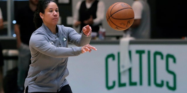 FILE - In this July 1, 2019, file photo, Boston Celtics assistant coach Kara Lawson passes the ball at the team's training facility in Boston. Celtics guard Gordon Hayward said Lawson has already made her presence felt. “She’s been good as far as just the experience she has as a basketball player,” Hayward said. “Reading the game and kind of little things she sees coaching on the sideline. Having somebody that well-versed in basketball, that experience is good.” (AP Photo/Charles Krupa, File)