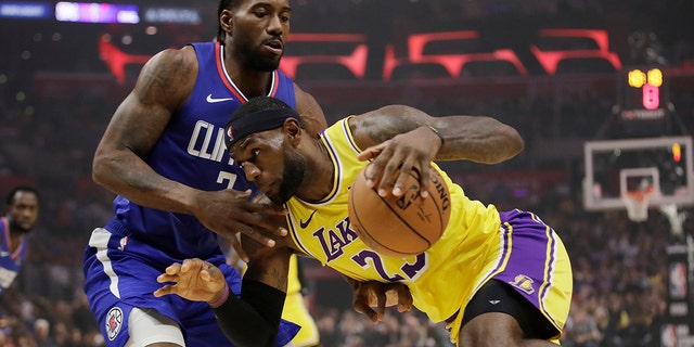 Los Angeles Lakers' LeBron James, right, is defended by Los Angeles Clippers' Kawhi Leonard during the first half of an NBA basketball game Tuesday, Oct. 22, 2019, in Los Angeles. (AP Photo/Marcio Jose Sanchez)