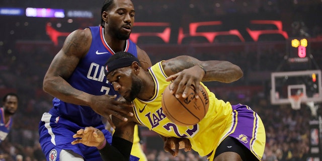Los Angeles Lakers' LeBron James, right, is defended by Los Angeles Clippers' Kawhi Leonard during the first half of an NBA basketball game Tuesday, Oct. 22, 2019, in Los Angeles. (AP Photo/Marcio Jose Sanchez)