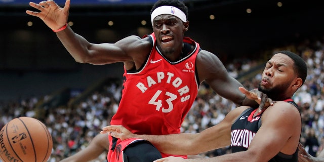 Toronto Raptors' Pascal Siakam, left, fights for a loose ball with Houston Rockets' Eric Gordon during the first half of an NBA preseason basketball game Thursday, Oct. 10, 2019, in Saitama, near Tokyo. (AP Photo/Jae C. Hong)