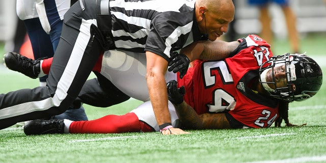 Referee Terry McAulay (77) breaks up an altercation between Atlanta Falcons running back Devonta Freeman (24) and Los Angeles Rams defensive tackle Aaron Donald during the second half of an NFL football game, Sunday, Oct. 20, 2019, in Atlanta. (AP Photo/John Amis)