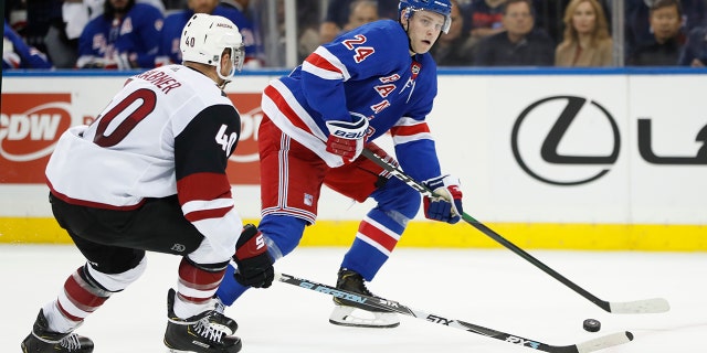 New York Rangers right wing Kaapo Kakko (24) looks to pass the puck as Arizona Coyotes right wing Michael Grabner (40) defends during the second period of an NHL hockey game Tuesday, Oct. 22, 2019, in New York. (AP Photo/Kathy Willens)