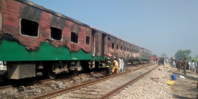 Pakistani officials examine a train damaged by a fire in Liaquatpur, Pakistan, Thursday, Oct. 31, 2019. A massive fire engulfed three carriages of the train traveling in the country's eastern Punjab province (Associated Press)