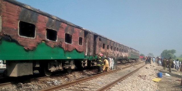 Pakistani officials examine a train damaged by a fire in Liaquatpur, Pakistan, Thursday, Oct. 31, 2019. A massive fire engulfed three carriages of the train traveling in the country's eastern Punjab province (Associated Press)