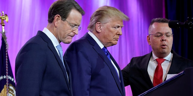 U.S. President Donald Trump prays between Tony Perkins, President of the Family Research Council, and Pastor Andrew Brunson (R) at the Family Research Council's annual gala in Washington, U.S., October 12, 2019.