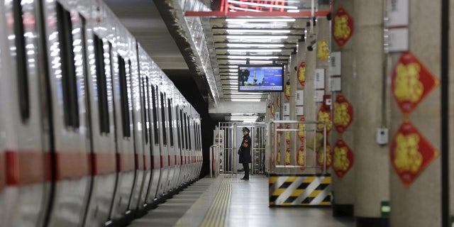 A member of security personnel stands on duty on an empty train platform inside a station in Beijing in 2016. (REUTERS/Jason Lee)