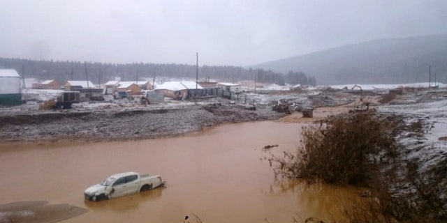 In this image made from video provided by Russian Emergency Situations Ministry press service, the view after a dam burst at a small gold mine in Siberia.