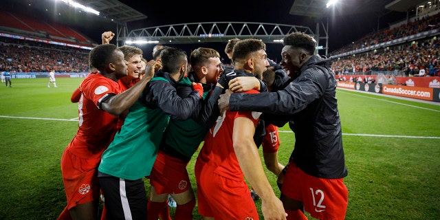 Canada midfielder Alphonso Davies (12) looks at forward Lucas Cavallini as they celebrate Cavallini's goal against the United States during the second half of a CONCACAF Nations League soccer match Tuesday, Oct. 15, 2019, in Toronto. (Cole Burston/The Canadian Press via AP)