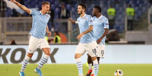Lazio's Sergej Milinkovic-Savic, left, celebrates after scoring his side's first goal during the Europa League Group E soccer match between Lazio and Rennes, at Rome's Olympic Stadium, Thursday, Oct. 3, 2019. (AP Photo/Alessandra Tarantino)