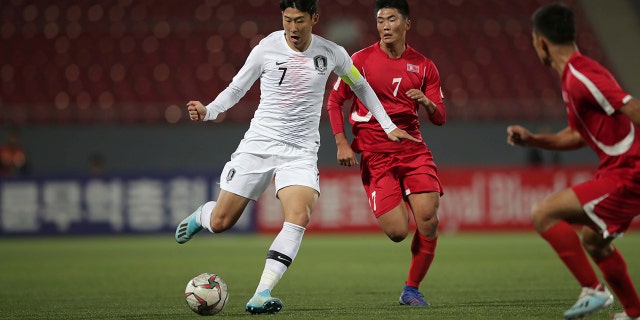 In this photo provided by the Korea Football Association, South Korea's Son Heung-min, left, fights for the ball against North Korea's Han Kwang Song during their Asian zone Group H qualifying soccer match for the 2022 World Cup at Kim Il Sung Stadium in Pyongyang, North Korea, Tuesday, Oct. 15, 2019. (The Korea Football Association via AP).
