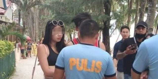 The woman wearing the white thong bikini was cited after police received complaints from other Boracay Island beachgoers.