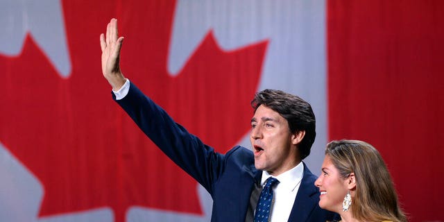 Justin Trudeau dan istrinya, Sophie Gregoire Trudeau, melambai saat tampil di markas pemilihan Partai Liberal di Montreal, 21 Oktober 2019. (Ryan Remiorz / The Canadian Press via AP)