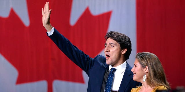 Liberal leader Justin Trudeau and wife Sophie Gregoire Trudeau wave as they go on stage at Liberal election headquarters in Montreal, Monday, Oct. 21, 2019. (Ryan Remiorz/The Canadian Press via AP)