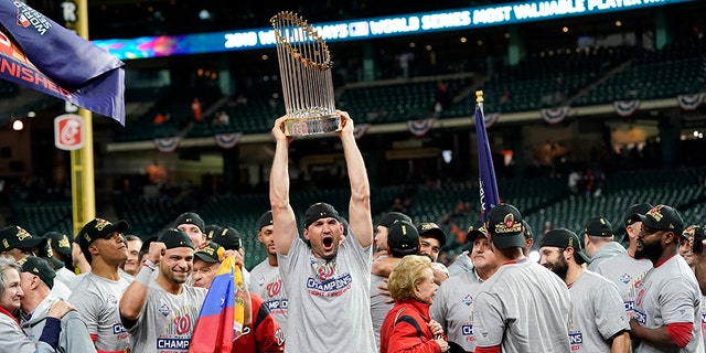 Washington Nationals catcher Yan Gomes celebrates the the trophy after Game 7 of the baseball World Series against the Houston Astros Wednesday, Oct. 30, 2019, in Houston. The Nationals won 6-2 to win the series. 