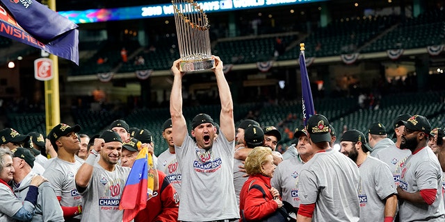 Washington Nationals catcher Yan Gomes celebrates the the trophy after Game 7 of the baseball World Series against the Houston Astros Wednesday, Oct. 30, 2019, in Houston. The Nationals won 6-2 to win the series. 