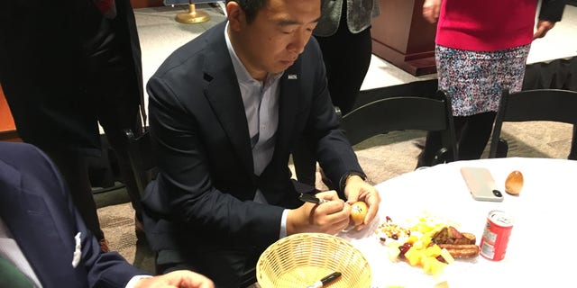 Democratic presidential candidate Andrew Yang signs the famed wooden eggs ahead of speaking at 'Politics and Eggs' at Saint Anselm College in Manchester, NH on Wednesday, Oct. 23, 2019