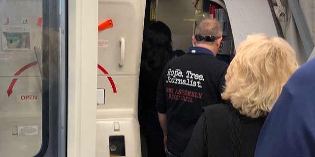 A United Airlines passenger, pictured, was recently spotted wearing a T-shirt that alluded to the lynching of journalists on a flight from Los Angeles to Boston.