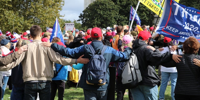 Protesters link arms at the March for Trump rally Thursday, symbolically standing united behind President Trump.