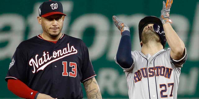 Houston Astros' Jose Altuve, right, celebrates next to Washington Nationals second baseman Asdrubal Cabrera after a double during the fifth inning of Game 3 of the baseball World Series Friday, Oct. 25, 2019, in Washington. (Associated Press)