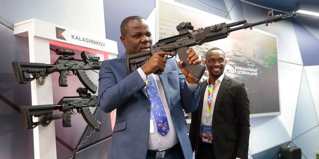 A visitor examines a Kalashnikov weaponry at an exhibition by Kalashnikov company on the sidelines of African countries at the Russia-Africa summit in the Black Sea resort of Sochi, Russia, Thursday, Oct. 24, 2019.
